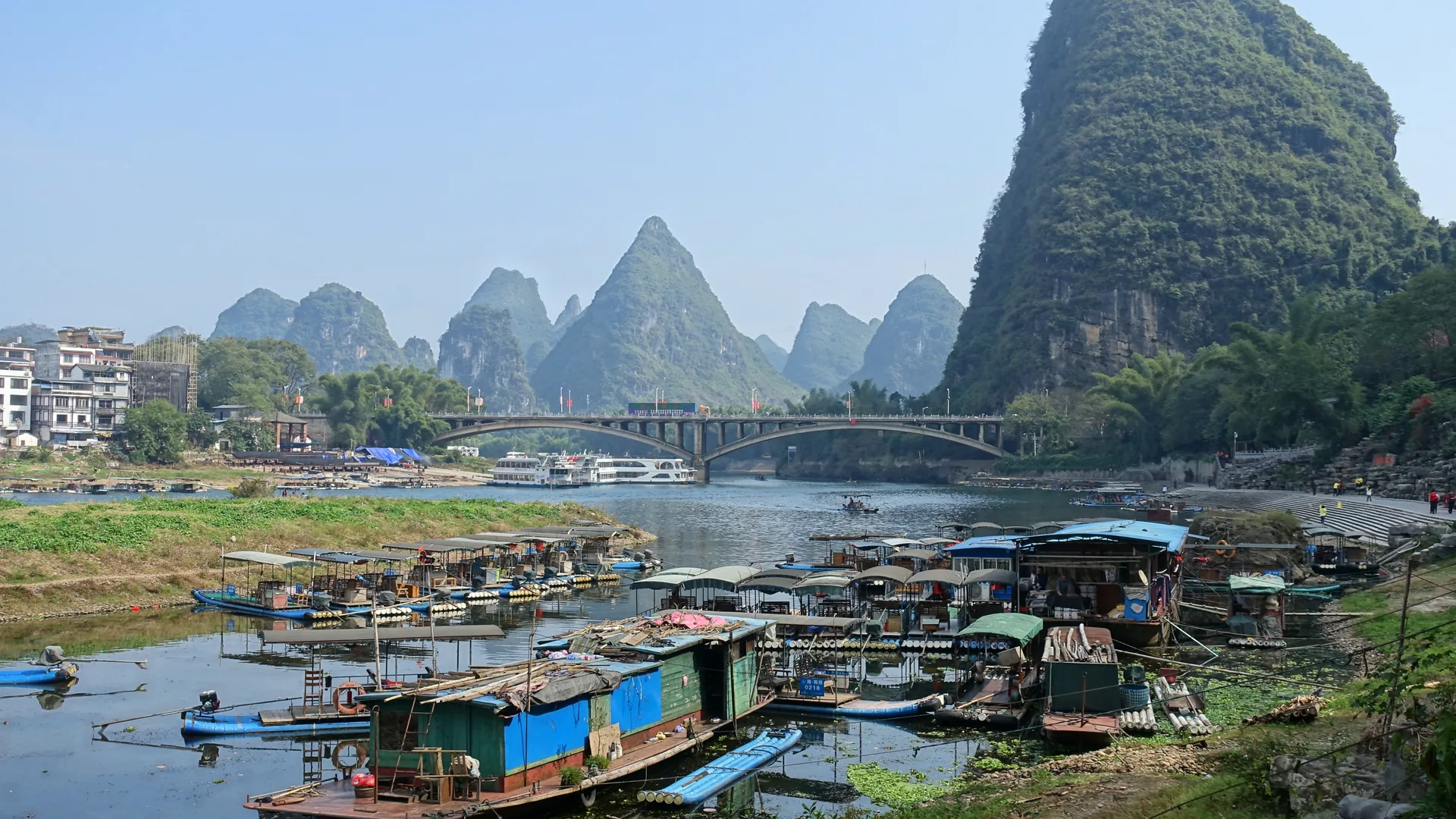 Illuminated karst mountains reflected in the Li River at night near Yangshuo, China, with coloured stage lighting on the water